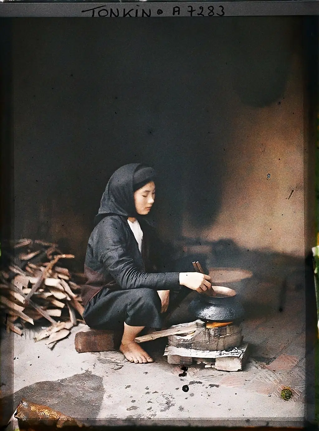 Một cô gái trẻ thuộc tầng lớp khá giả đang nấu cơm ở xứ Đàng Ngoài