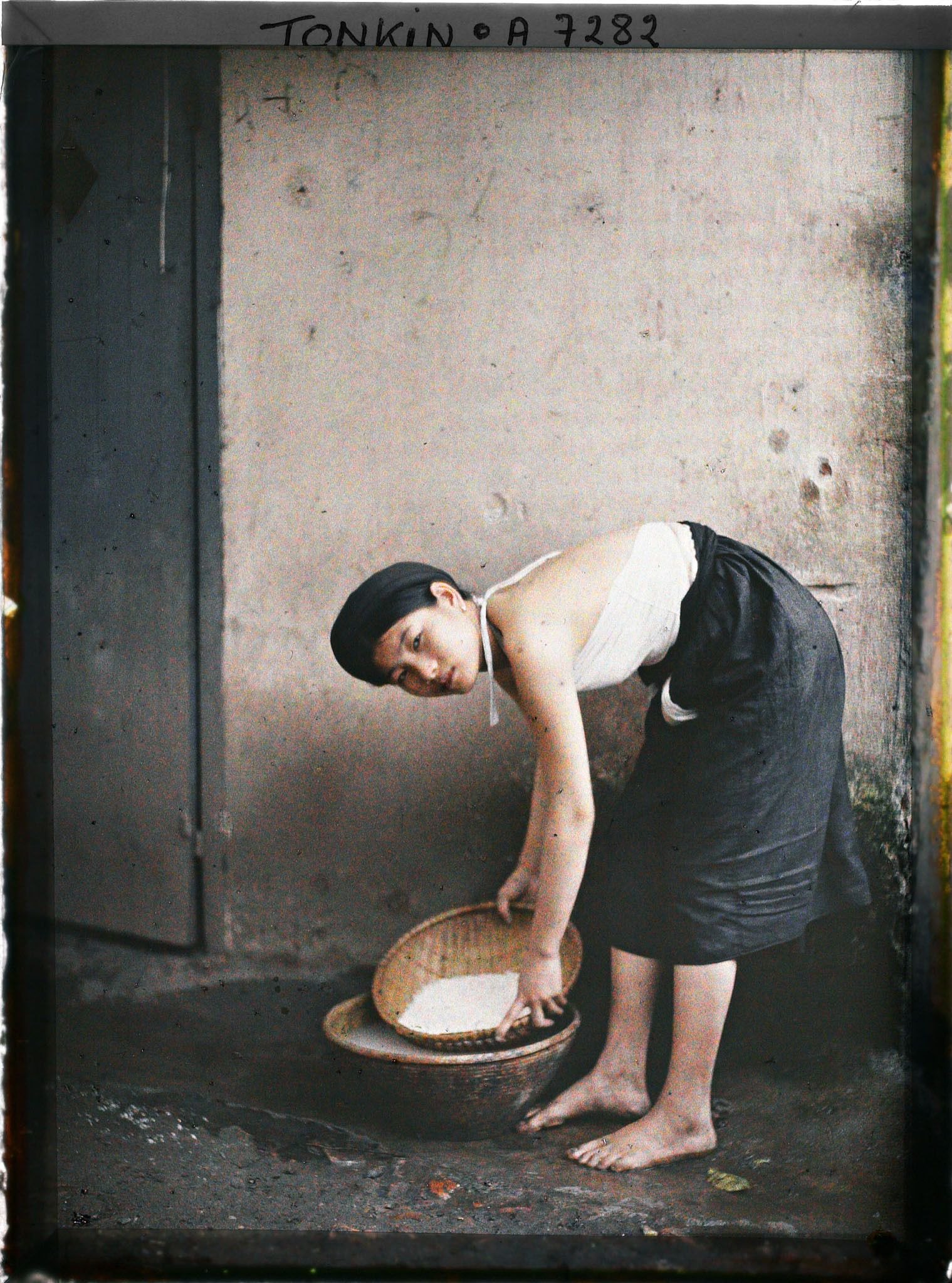 Thiếu nữ An Nam vo gạo thổi cơm cho mâm cơm gia đình